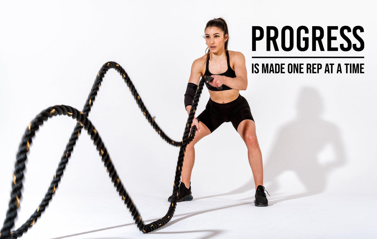 Motivational gym workout image with woman using battle ropes, featuring the quote 'Progress is made one rep at a time'.