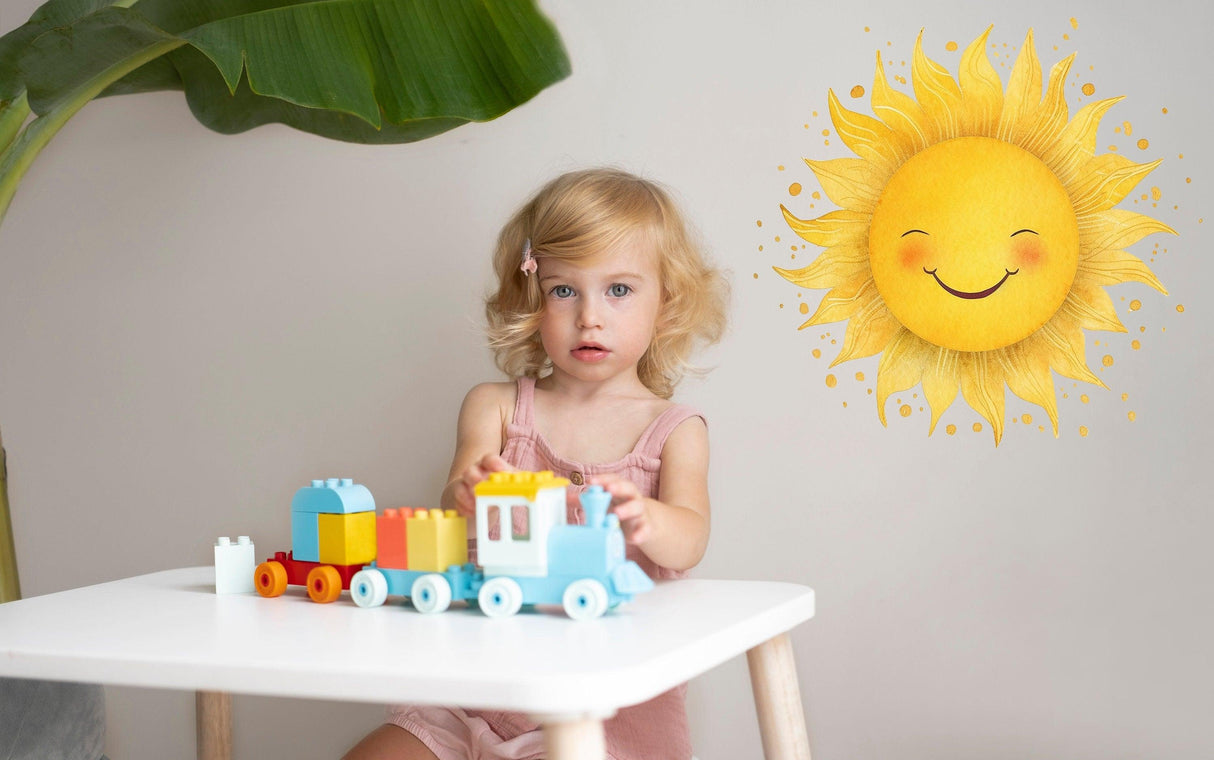 Cute toddler playing with a colorful toy train in front of a whimsical sunburst wall sticker.