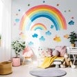 Colorful whimsical rainbow wall stickers with clouds and stars in a bright kids' room decor.