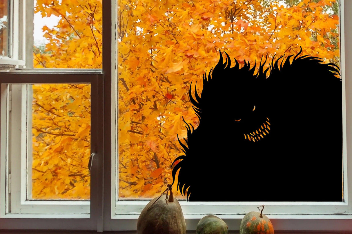 Creepy Halloween Monster Window Decal silhouette against orange autumn leaves.