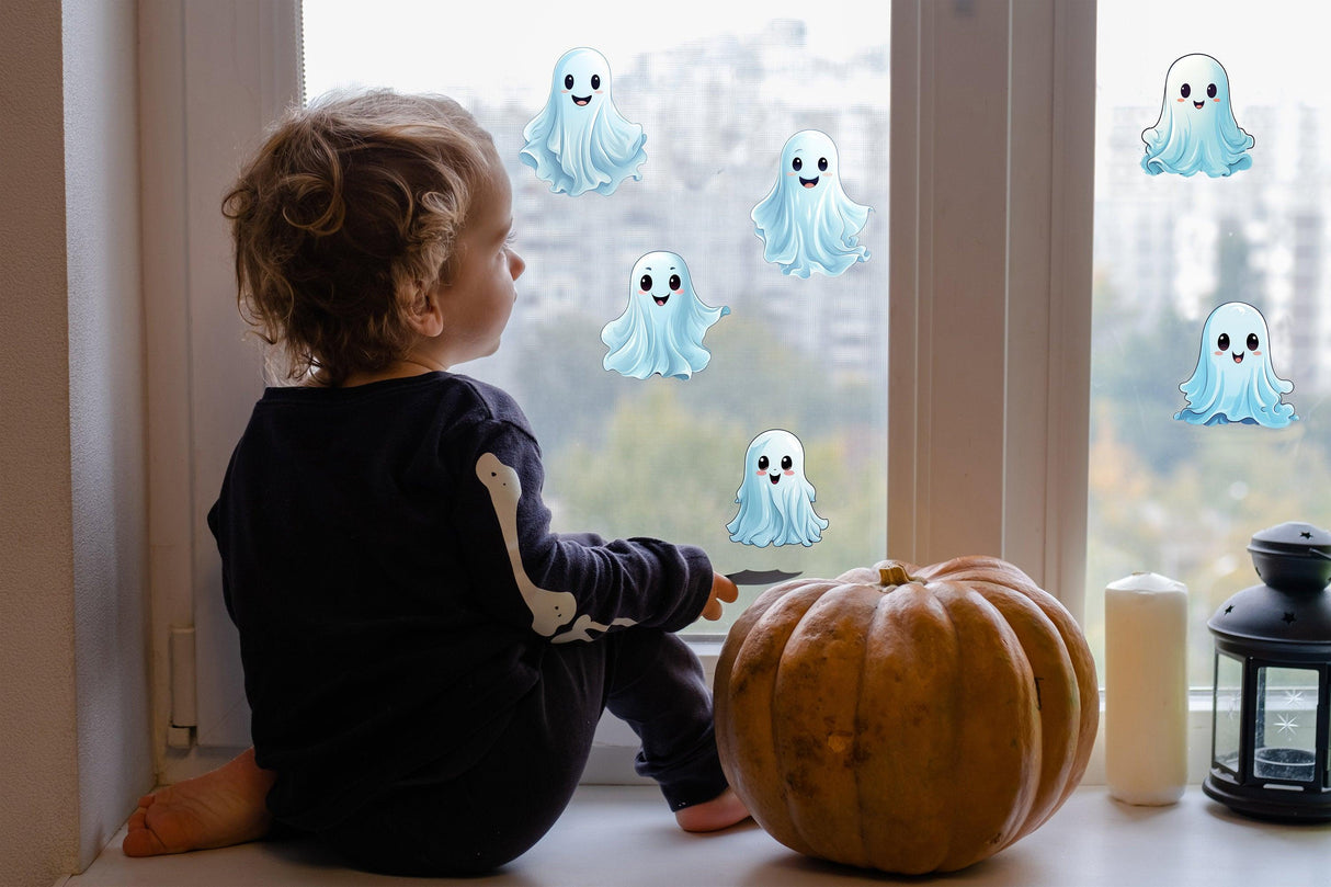 Child looking at white ghost window decals on a Halloween-themed window with a pumpkin nearby.