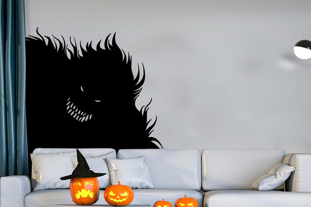 Spooky black monster decal on wall with Halloween pumpkins and witch hat in living room setting.