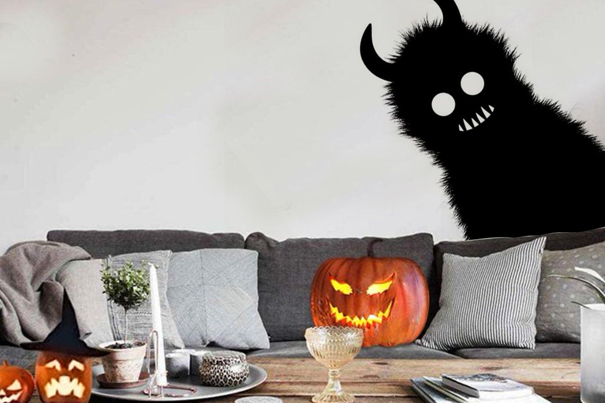 Spooky Monster Shadow Sticker on wall with Halloween pumpkins in cozy living room setting.