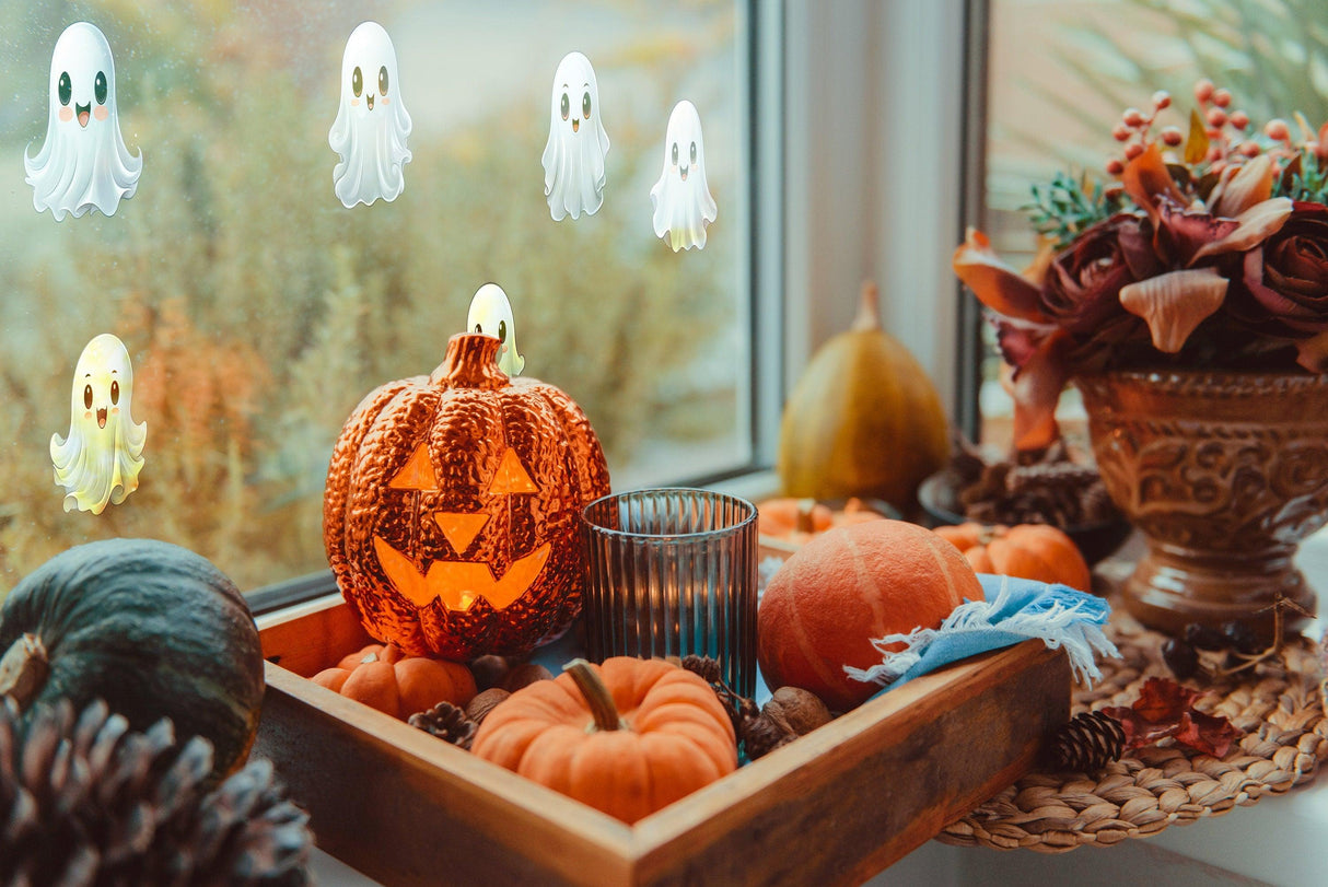 Decorative Halloween scene with frosted ghost window stickers, carved pumpkin, and seasonal decor.