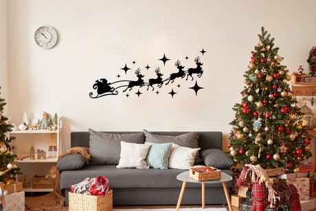 Santa sleigh with reindeer silhouette decal above cozy sofa and Christmas trees for festive home decor.