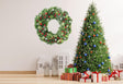 Verdant Christmas wreath wall decal with green leaves and red berries above a decorated Christmas tree and gifts.