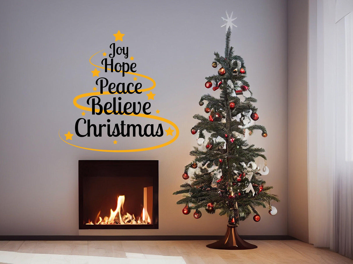 Colorful Christmas quote vinyl sticker on wall with decorative tree and fireplace, featuring 'Joy Hope Peace Believe Christmas'.