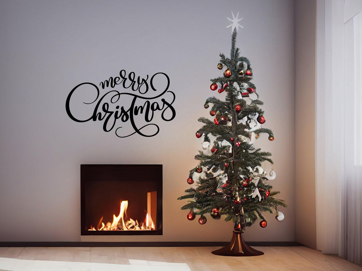Elegant 'Merry Christmas' wall vinyl sticker above a decorated Christmas tree and cozy fireplace.