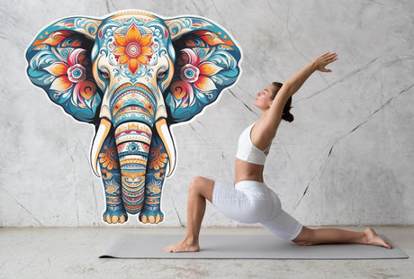 Woman practicing yoga in front of a vibrant floral elephant wall decal, adding tranquility to her space.