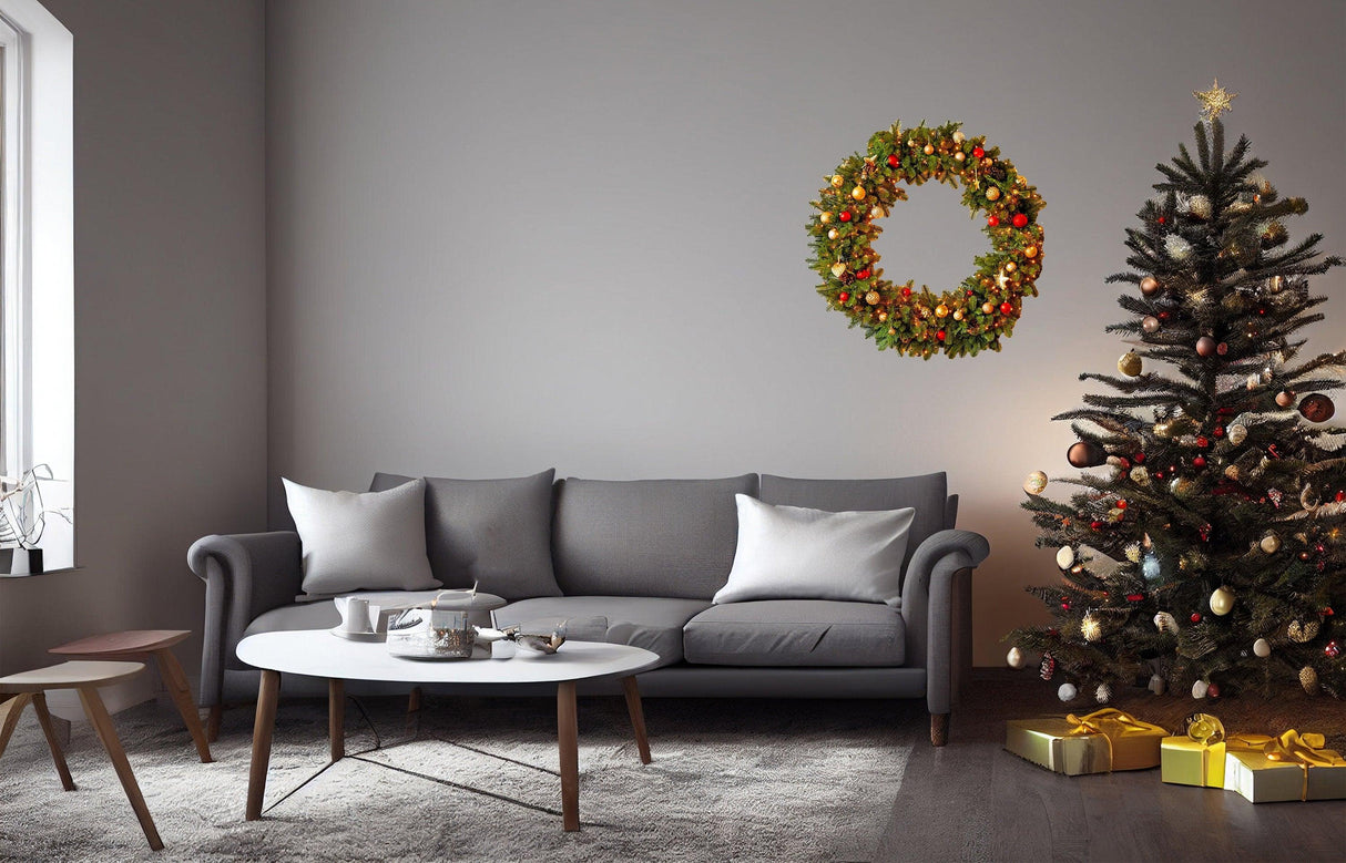 Christmas wreath wall decal above a grey sofa with a decorated tree and gifts, adding festive cheer to the living room.