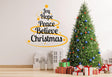 Colorful Christmas quote wall decal with 'Joy Hope Peace Believe Christmas' near a decorated tree and gifts.