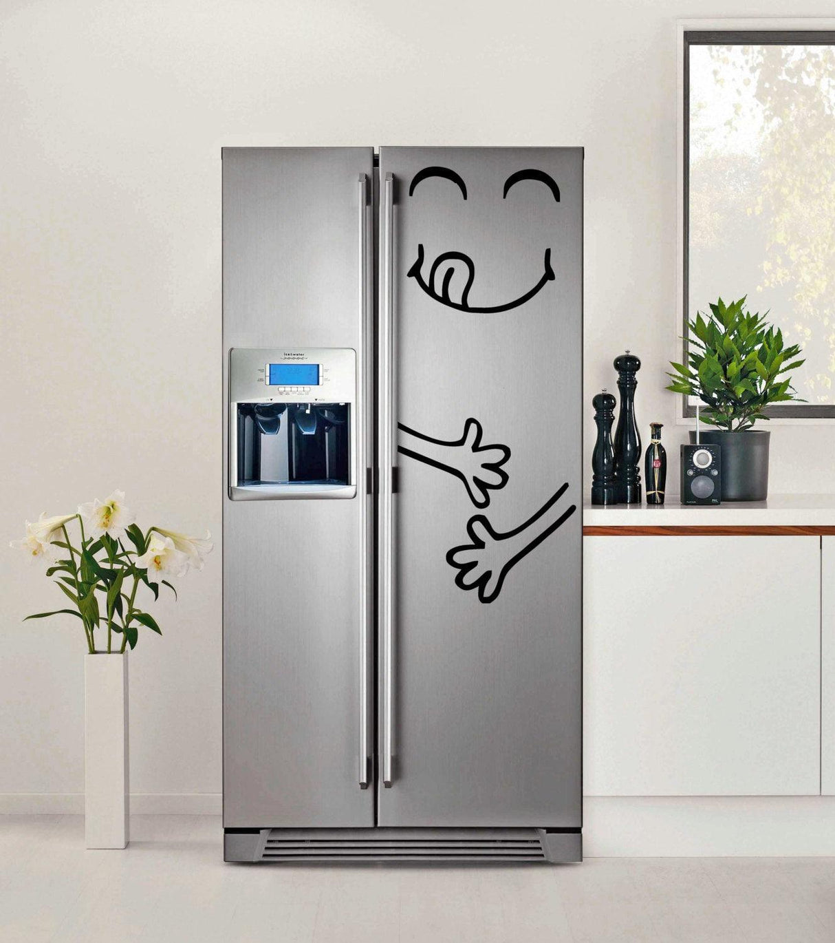 Cute vinyl sticker design on a silver fridge featuring a smiling face and playful hands for kitchen decor.