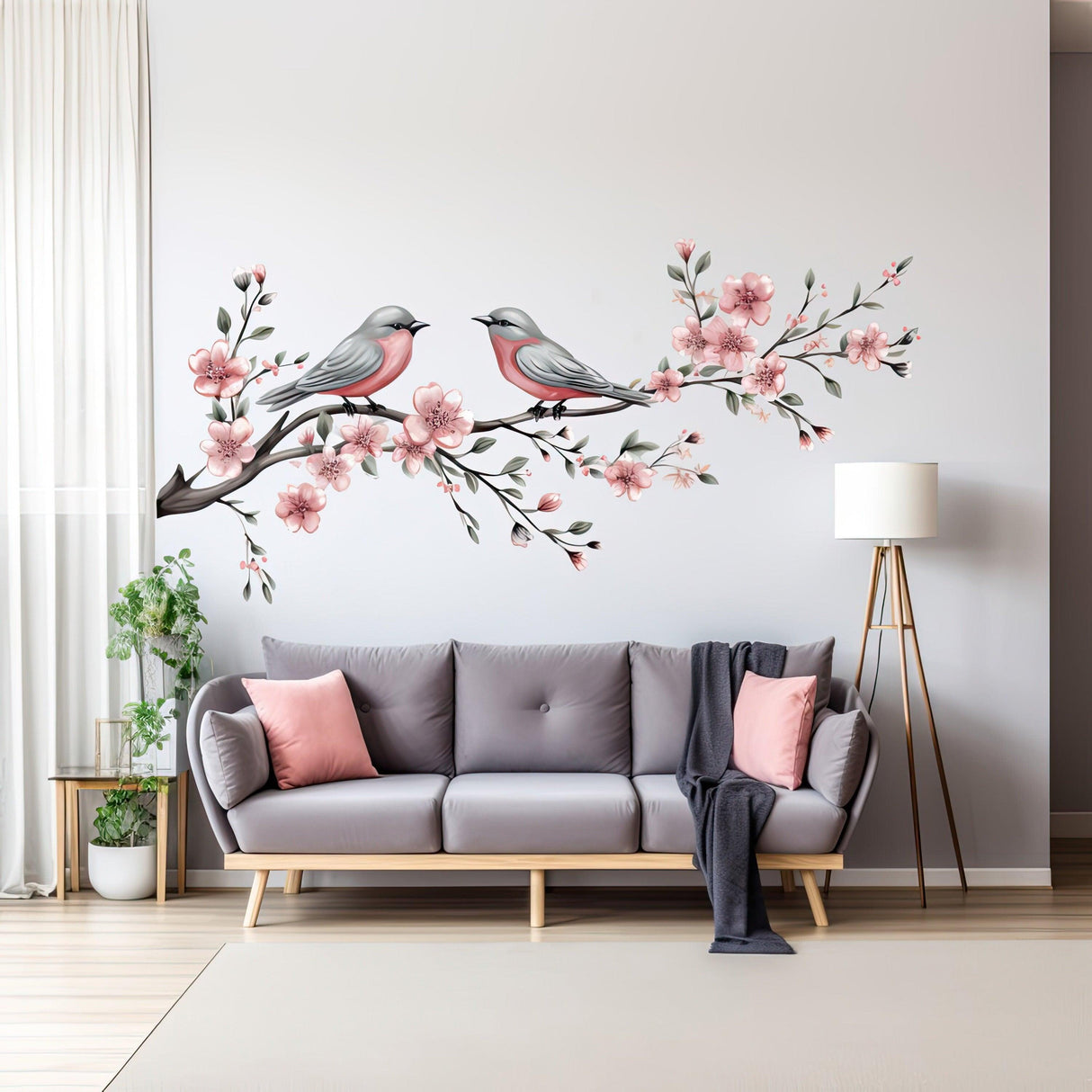 Elegant vinyl wall decal of birds and flowers above a gray sofa in a stylish living room.