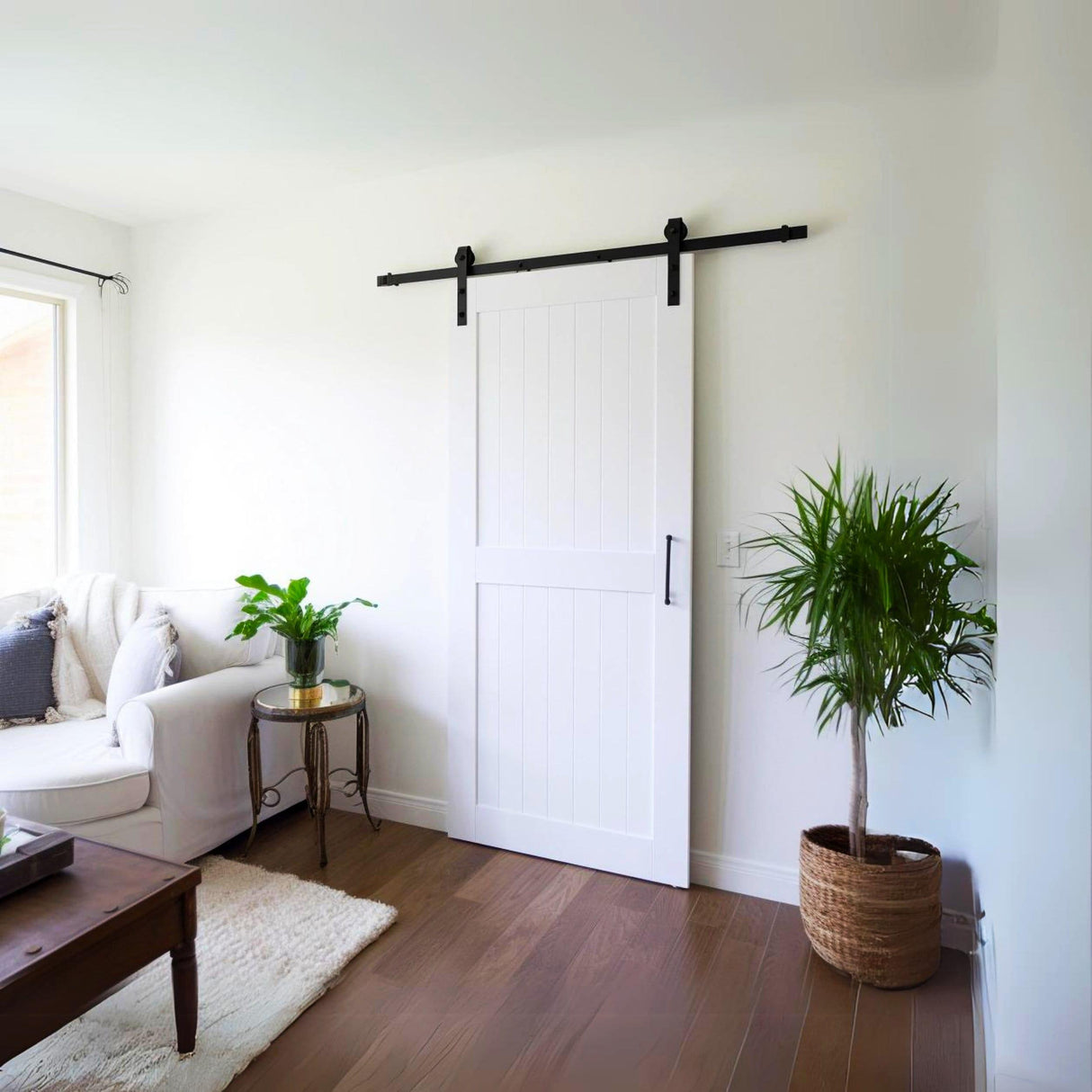 White rustic barn door in a modern living room with plants and cozy decor, enhancing the rustic charm of the space.