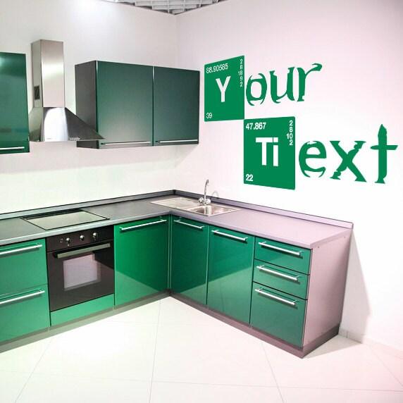 Custom text vinyl sticker on a green kitchen wall featuring personalized name in a creative design.
