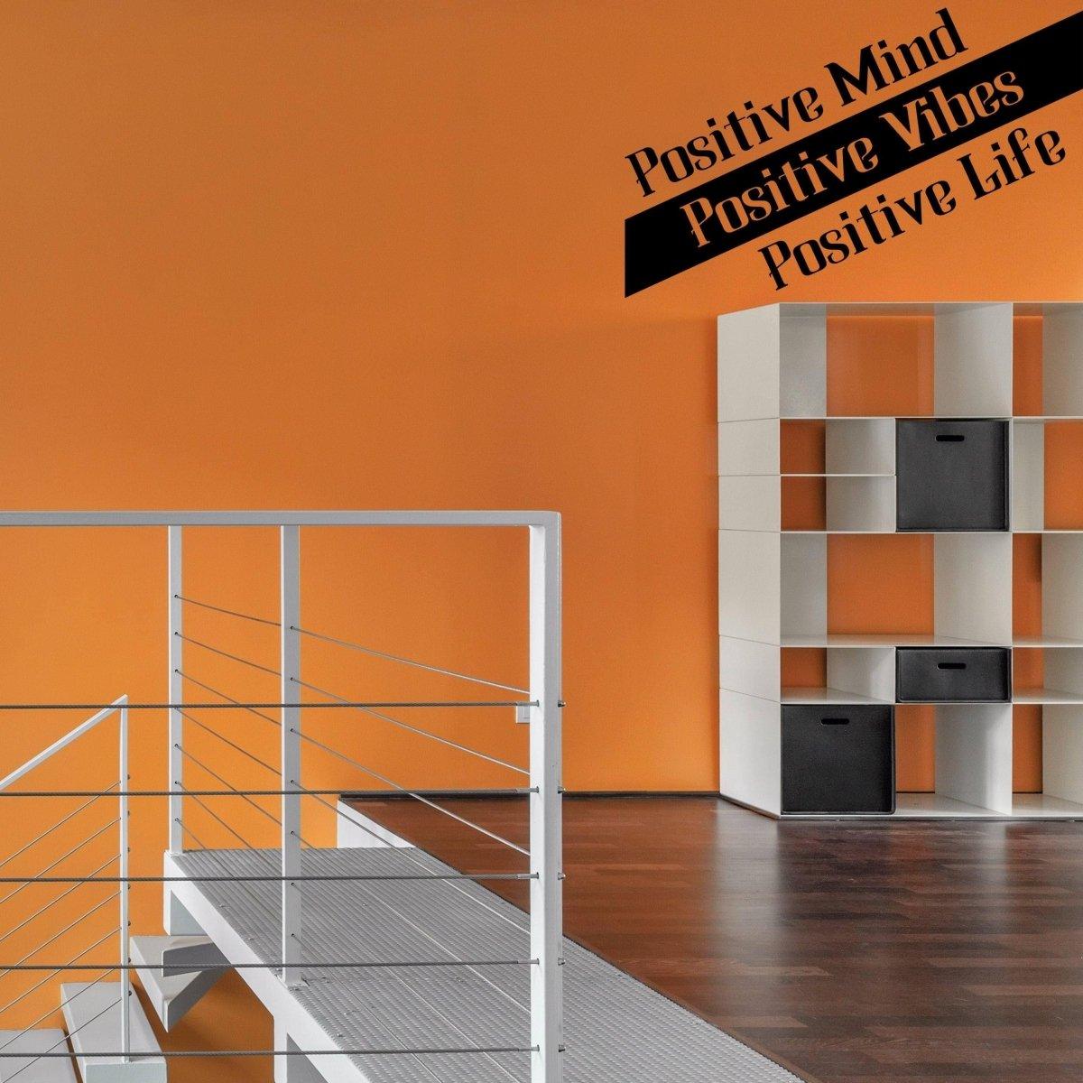 Motivational vinyl decal on orange wall displaying 'Positive Mind, Positive Vibes, Positive Life' in modern interior design.