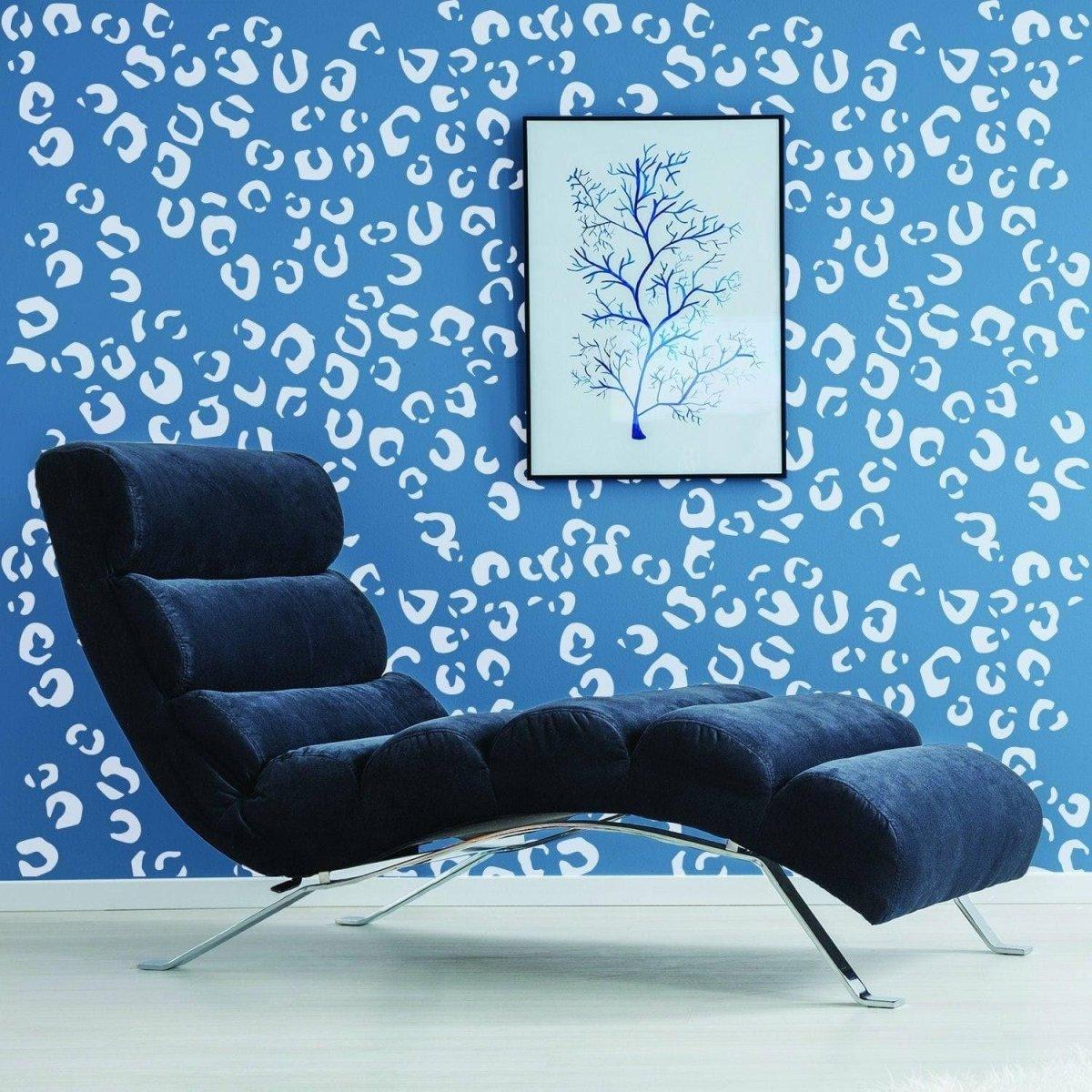 Stylish lounge chair in front of a blue wall with leopard print decals and framed artwork.