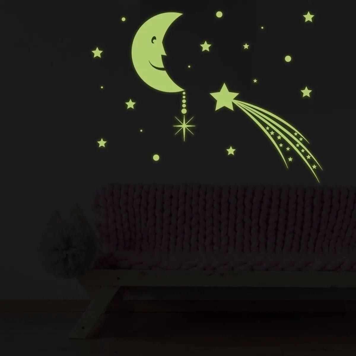 Glowing moon and star wall decals illuminating a dark room, perfect for children's decor.