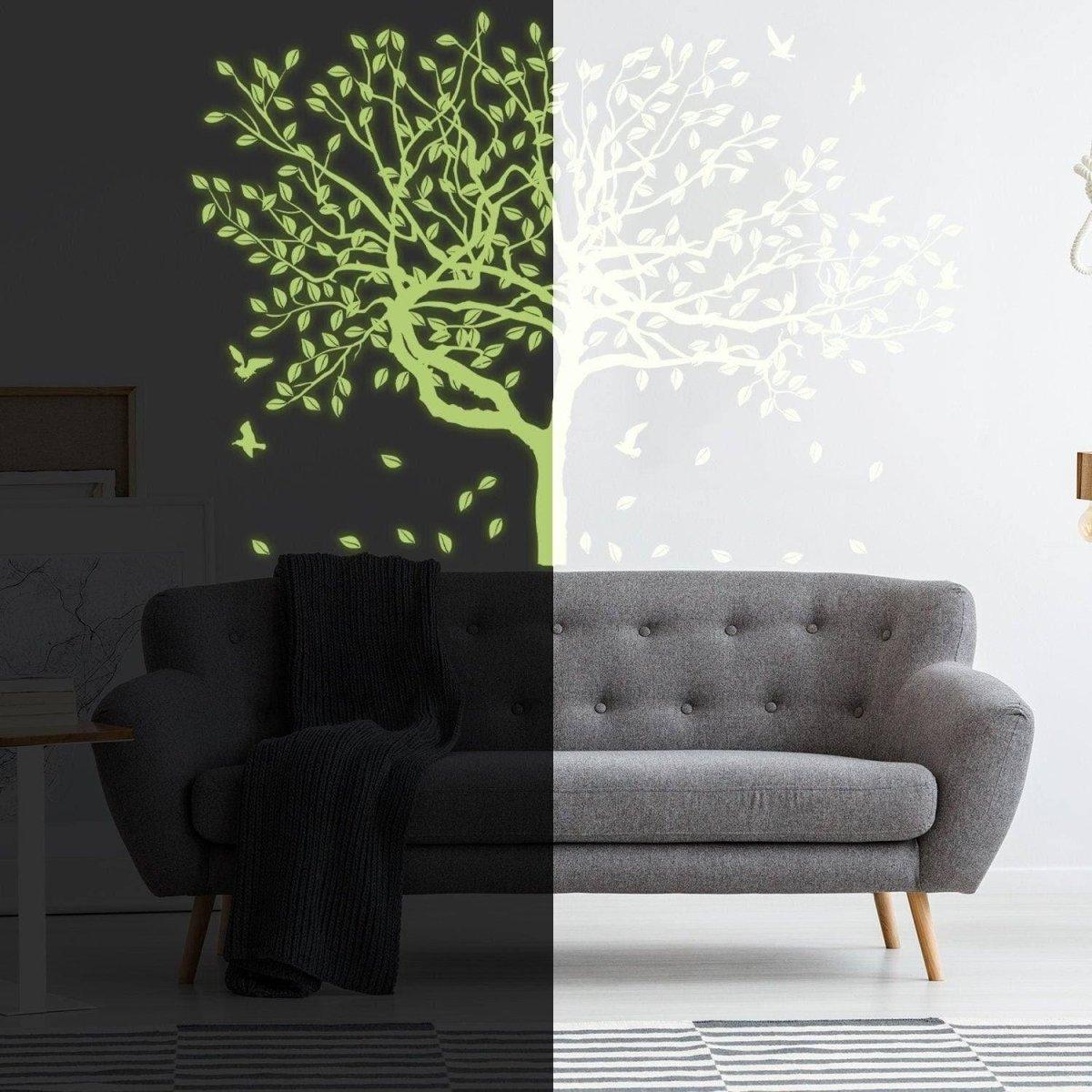 Glow-in-the-dark forest wall decal on a living room wall beside a stylish gray sofa.