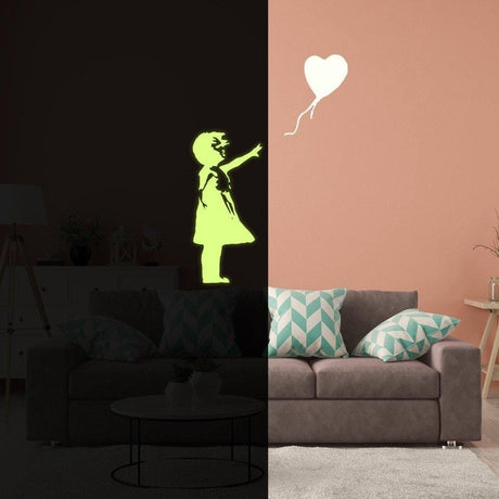 Luminescent girl silhouette with heart balloon wall decal glowing in a dark room over a cozy couch.