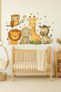 A nursery with a wooden crib and a large safari-themed wall decal featuring a lion, elephant, giraffe, zebra, and owl. The wall is neutral, and the soft, pastel tones of the animals create a cozy jungle atmosphere.