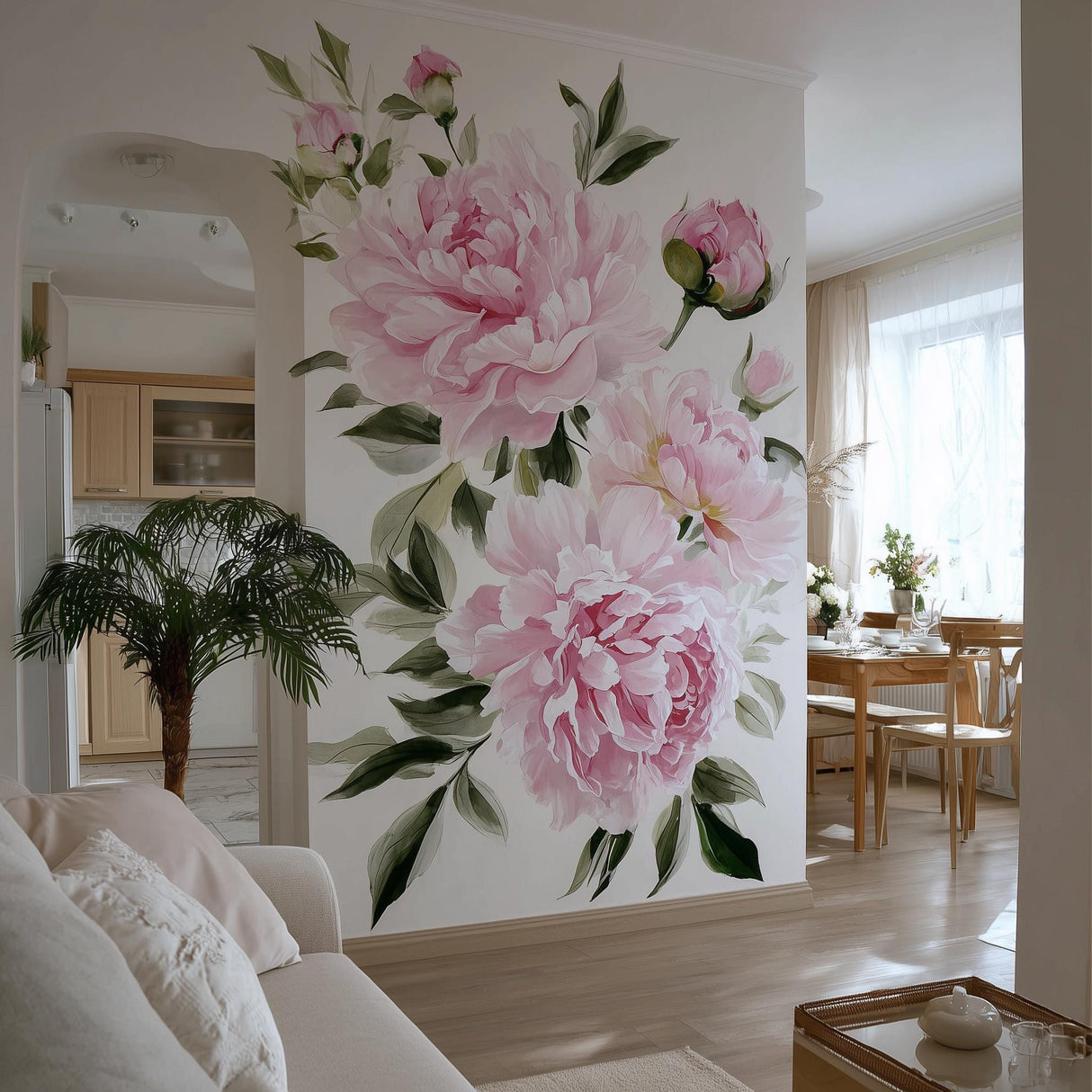 A bright, elegant living space with a large wall mural featuring soft pink watercolor peonies and green leaves. The floral design fills an accent wall between a cozy sitting area and a natural wood dining space, adding romantic charm and vibrancy.