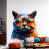 Printed wall decal of a colorful cat wearing large reflective sunglasses. The decal is cut along the shape of the cat and applied to a white wall, shown above a sofa with orange and blue cushions.