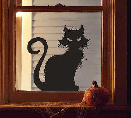 Vinyl window decal of a scary black cat silhouette with pointed ears and glowing eyes, placed on a window with a pumpkin and spider webs on the windowsill. The design is cut from solid black vinyl with no background.