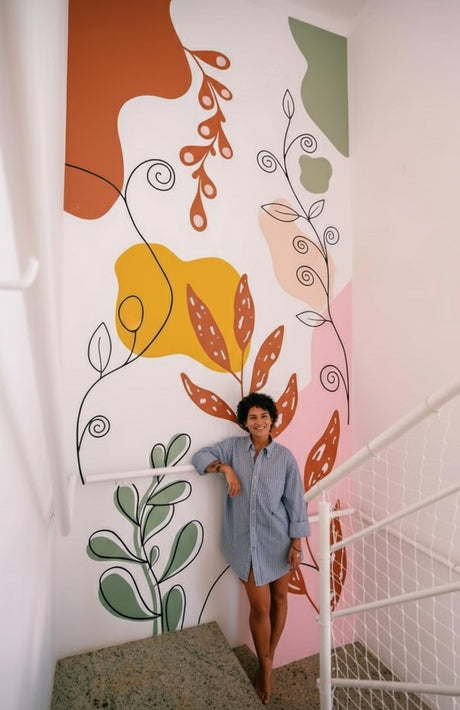 Large abstract botanical wall decal with colorful shapes and flowing lines applied to a staircase wall. The design includes orange and green leaves, organic lines, and large pink, yellow, and green color blocks on a white background.