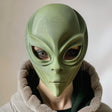 3D printed alien face mask with smooth organic shape, worn by an adult model indoors, realistic sci-fi costume accessory made from matte PLA plastic