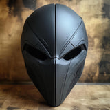 Close-up of a matte black 3D printed full-face cosplay mask with angular, futuristic design and tactical helmet-style contours, displayed upright.
