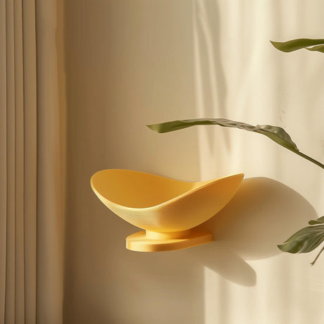 3D printed wall-mounted shelf shaped like a shallow yellow bowl, matte PLA texture, used as a floating wall dish in a cozy sunlit interior.