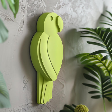3D printed wall decor shaped like a minimalist parrot silhouette in a bold green color, matte PLA design mounted on a textured interior wall with plants nearby