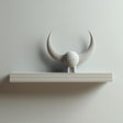 3D printed wall-mounted shelf with a small horned creature figure standing on a rectangular ledge against a light-colored wall.