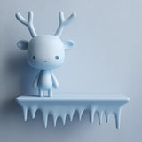 3D printed wall shelf with a smooth icicle-edge ledge and a small antlered character standing on top, mounted on a light-colored wall.