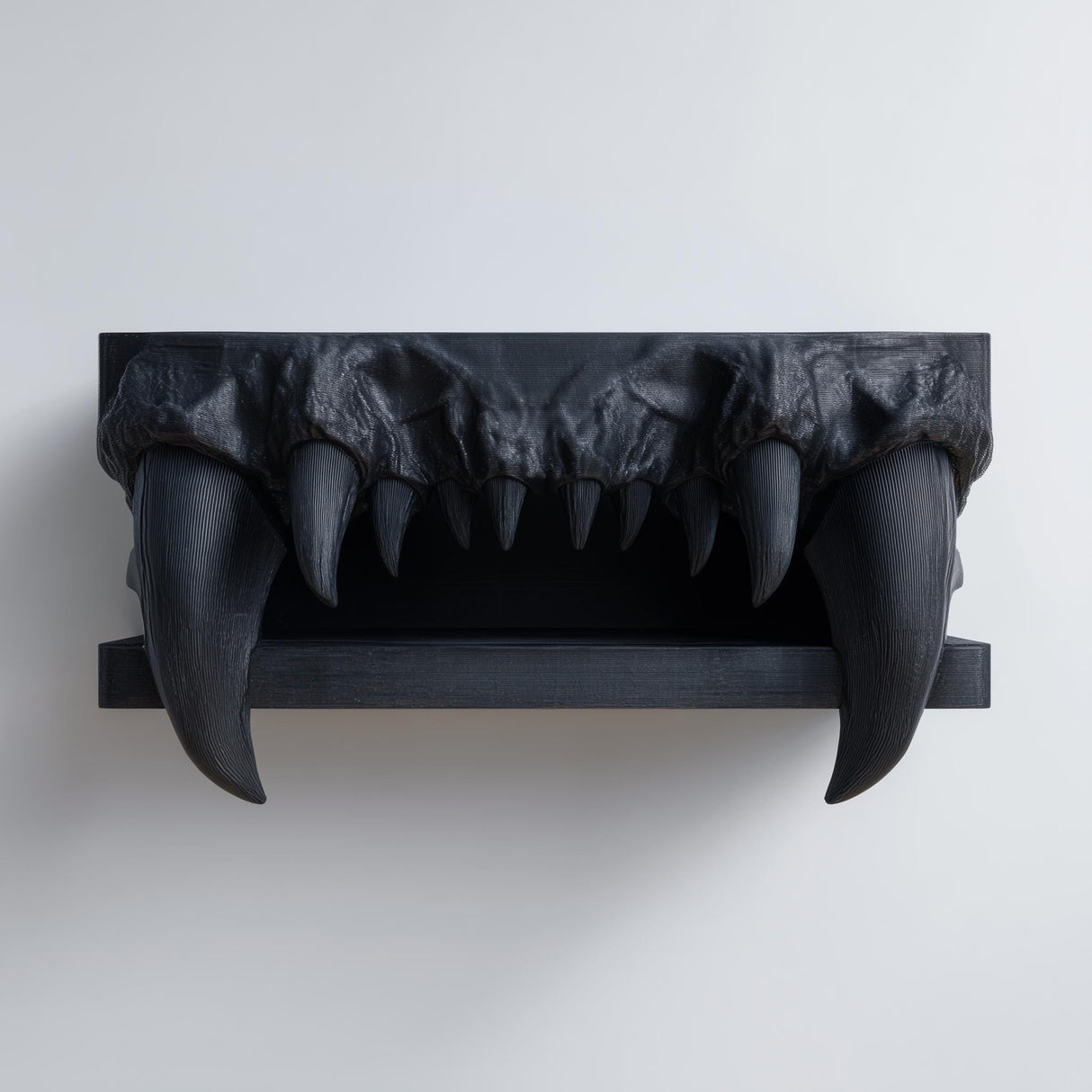 3D printed matte black wall shelf with a snarling vampire jaw and long curved fangs forming a horror-themed floating ledge on a light wall.