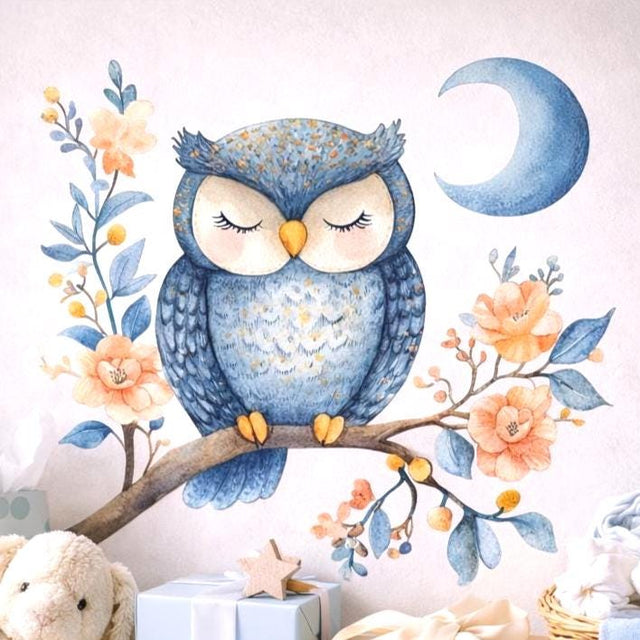 A watercolor illustration of a round blue owl with closed eyes perched on a brown branch. The branch is decorated with soft orange flowers and blue leaves. A blue crescent moon is visible in the top right corner against a light grey background.