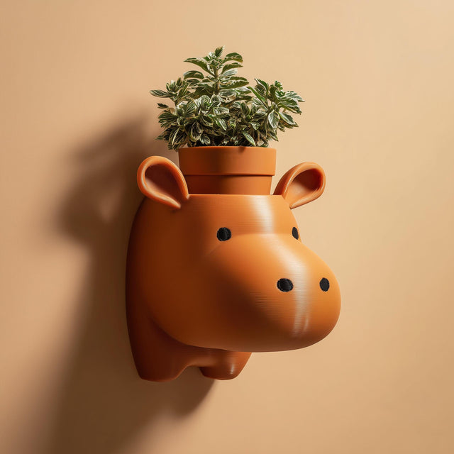 3D printed cute hippo head wall planter shelf with integrated plant holder, mounted on a warm neutral interior wall.