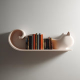 3D printed minimalist cat shaped wall shelf with smooth sculptural form, used as a book shelf and mounted on a clean modern interior wall.