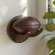 3D printed football with floating wall mount display holder in matte PLA mounted on a modern interior wall with soft natural lighting.