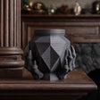 3D printed dark fantasy memorial urn with faceted geometric body and sculptural claw base displayed on a dark wooden mantel.