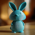 3D printed bunny memorial urn with removable lid displayed on a wooden tabletop in warm indoor lighting.