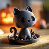 Cat-shaped jewelry organizer with a tray base holding rings and earrings on a wooden surface with pumpkins and warm indoor lighting in the background.
