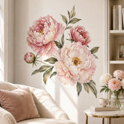 Watercolor arrangement of three large blush pink and cream peonies with one smaller bud, golden flower centers, and muted sage and olive-green leaves on a white background.