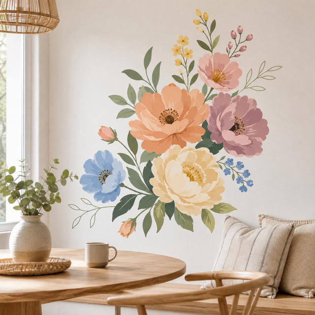Pastel floral bouquet with large peach, cream, dusty pink, and soft blue flowers, surrounded by small yellow and blue blossoms, delicate buds, and muted green leaves on a white background.