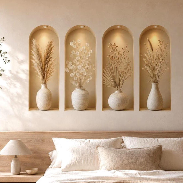 Four tall arched beige wall niches with warm overhead spotlights, each displaying a cream ceramic vase filled with a different dried botanical arrangement in soft neutral tones.