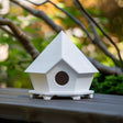 3D printed geometric birdhouse ornament with faceted roof and circular opening