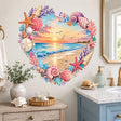 Heart-shaped watercolor beach scene with a pastel ocean sunset, gentle waves, flying seagulls, and a distant lighthouse, surrounded by pink, peach, cream, and lavender seashells, starfish, coral branches, sea glass, and small coastal stones.