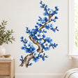 Tall blue blossom branch wall decal with a twisting brown trunk, cobalt and white flowers, and small blue buds.