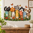 Five playful cats peeking over a colorful wooden garden fence with daisies, warm colored flowers, green leaves and orange butterflies.